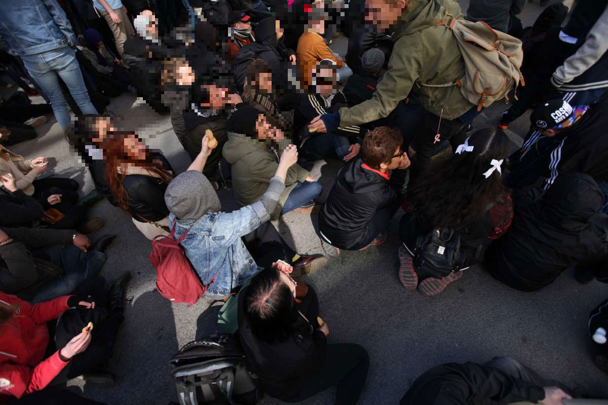 Motdemonstranterna sitter ner och får kakor. Motdemonstranterna sitter ner och får kakor.